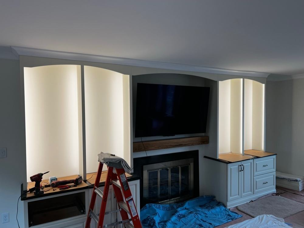 Lit built-in shelves on both sides of a fireplace