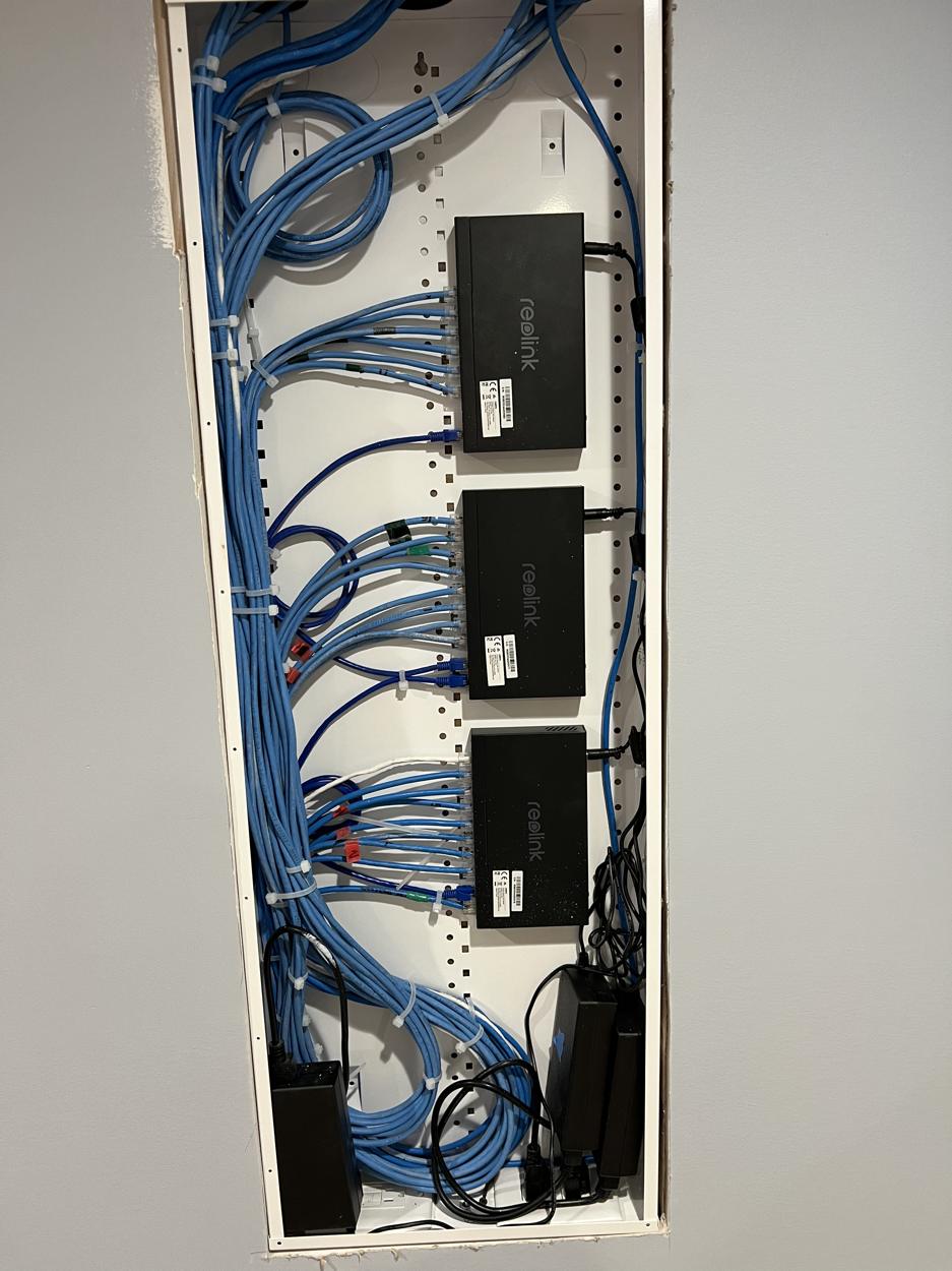 A structured wiring panel with neatly bundled network cables and switches